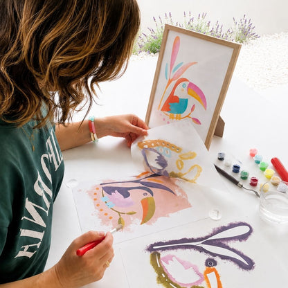 Femme réalisant un tableau toucan Panash Art avec pochoirs superposables et peinture acrylique, activité créative sans écrans alternative à la peinture au numéro